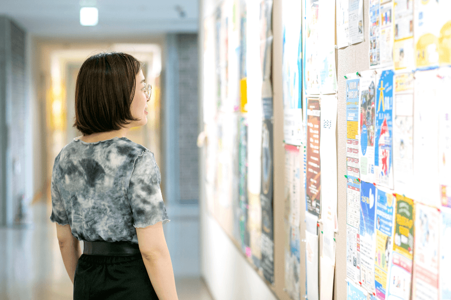 掲示物を確認する女性の写真